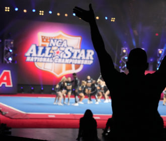 Coach cheering for team performing at NCA All Star Nationals