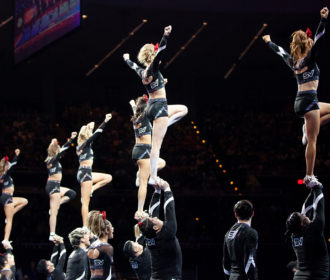 Cheerleaders stunting back view at NCA All Star Nationals
