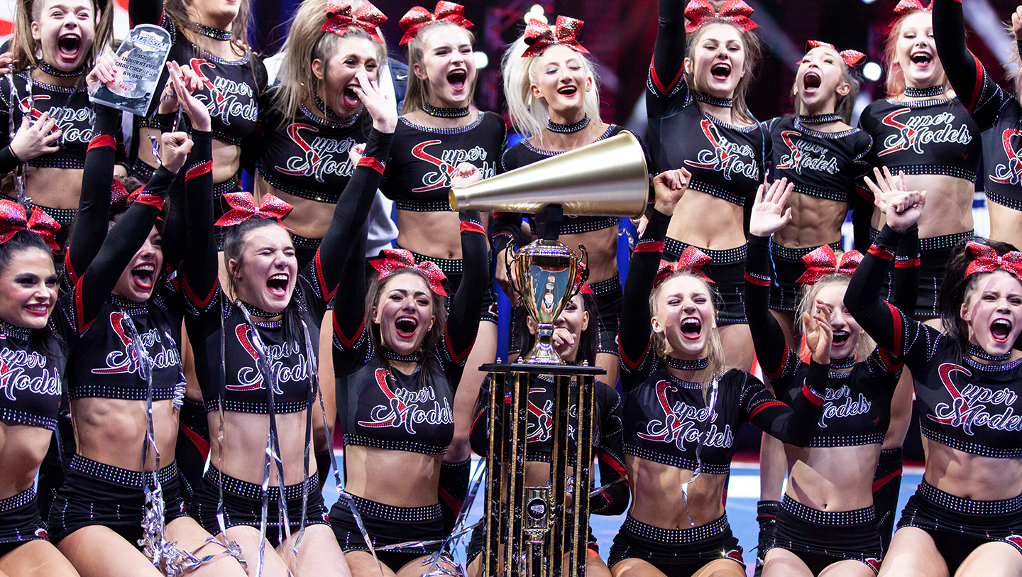 Cheerleaders celebrating with trophy and confetti at NCA All Star Nationals