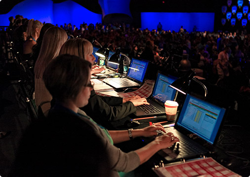 Varsity All Star Scoring judges sit on their computers at a competition