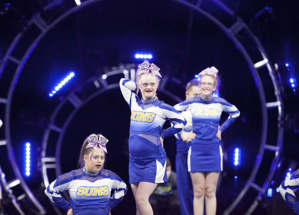 Cheerleader with disability poses on the performance floor