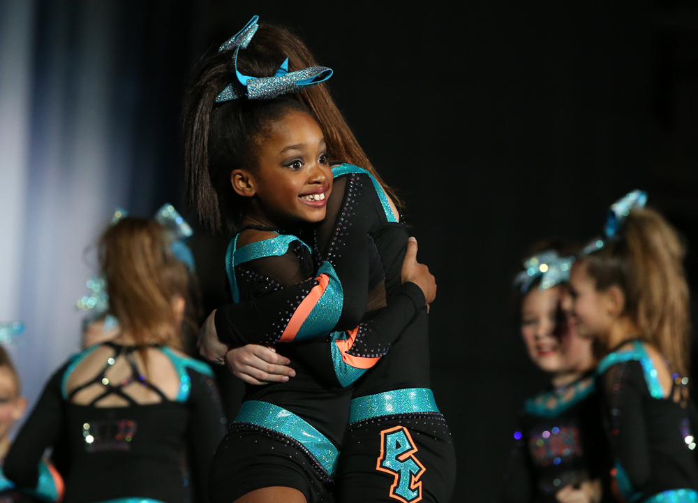 two cheerleaders hugging after performing a great routine